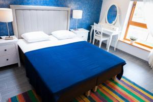 德鲁斯基宁凯Vila Nikolas的卧室配有蓝色和白色的床和书桌。
