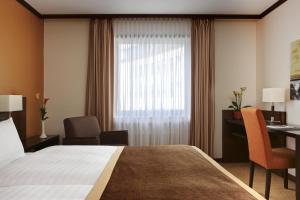 多特蒙德多特蒙德施泰根博阁酒店的配有一张床、一张书桌和一扇窗户的酒店客房