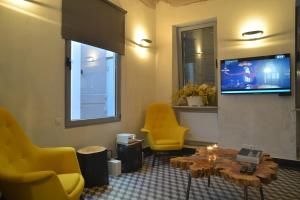 雅典当代雅典度假屋的客厅配有黄色椅子、桌子和电视