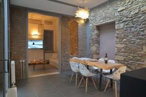 雅典当代雅典度假屋的一间设有石墙和桌椅的用餐室