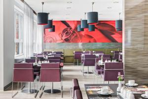 汉堡汉堡阿尔托纳城际酒店的一间带桌子和紫色椅子的用餐室