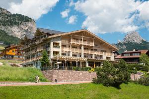 塞尔瓦迪加尔代纳山谷Hotel Portillo Dolomites 1966'的山中一座大型建筑,前面的人在步行