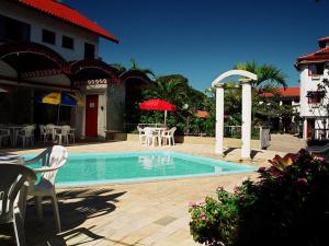 弗洛里亚诺波利斯索尔玛德佛洛瑞拉住宅酒店的游泳池配有椅子、桌子和遮阳伞