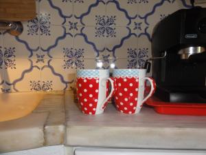 圣地亚哥-杜卡森Herdade do moinho的两个杯子坐在烤面包机旁边的柜台上