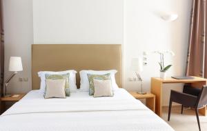 卡斯托里亚Chloe Luxury Hotel的卧室配有带枕头的白色床和书桌。