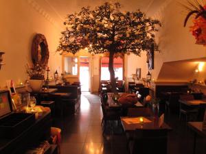 哈莱姆阿玛德斯酒店的一间设有桌椅的餐厅,还有一棵树