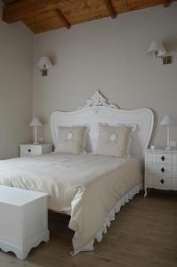 卢切拉Masseria Casanova的白色卧室配有一张带枕头的大白色床