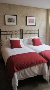 San Miguel de ValeroSueñoRural的一间卧室配有两张红色和白色床单