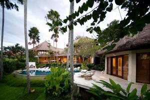 坎古Planta Boutique Resort的一座带游泳池的房屋和一座种植了棕榈树的庭院