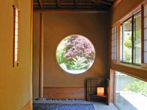松本桃山旅馆的墙上设有圆形窗户的房间
