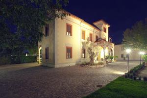 Rodigo蒂格里920自由度假别墅酒店的一座白色的大建筑,晚上有庭院