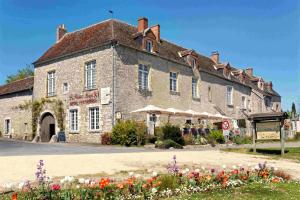 卢瓦尔河畔默恩Logis Hôtel Le Relais Louis XI的一座大石头建筑,前面有鲜花