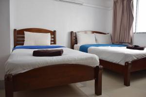 曼谷阿尔萨娜酒店的两张睡床彼此相邻,位于一个房间里