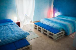 CastelfrentanoB&B Casa Tua的一间卧室配有两张带蓝色棉被的床
