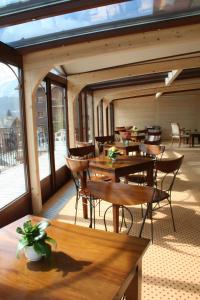 尚佩里瑞士酒店的餐厅设有木桌、椅子和窗户。