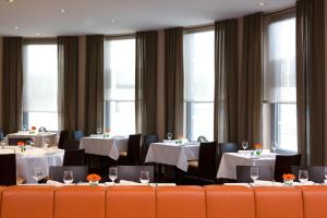 美因茨美因茨城际酒店的用餐室设有桌椅和窗户。