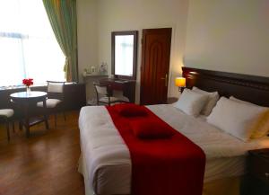 拉马拉城市客栈皇宫酒店的酒店客房设有一张大床和一张桌子。
