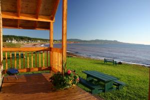 佩尔塞海洋自然度假屋的海滩上带野餐桌和长凳的木门廊