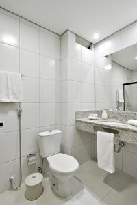 里贝朗普雷托Hotel Nacional Inn Ribeirão Preto的白色的浴室设有卫生间和水槽。