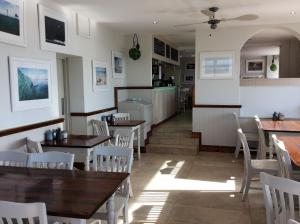圣约恩斯愉景湾度假屋的配有木桌和白色椅子的餐厅