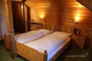 索普拉布扎诺Gasthof Schluff的木制客房内的一间卧室,配有一张床