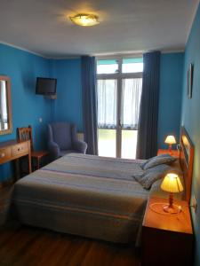 坎加斯-德奥尼斯阿吉拉里尔酒店的卧室配有床、椅子和窗户。