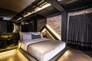 伊斯坦布尔81号城市阁楼酒店的一间卧室设有一张床和砖墙