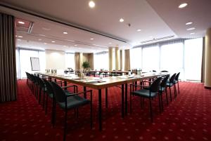 什未林什未林城际酒店 的大型会议室,配有长桌子和椅子