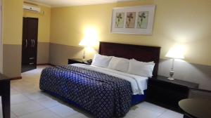 米德兰别墅酒店 - 米德兰的一间卧室配有一张大床和两盏灯