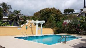 布里奇敦10 Springcourt Barbados的一座房子旁边的游泳池,带水滑梯
