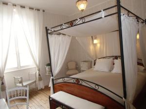 埃格利斯讷沃-当特赖格普罗维登斯酒店的一间卧室配有一张天蓬床和一把椅子