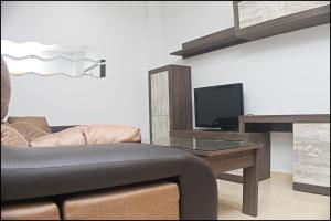 科尼尔-德拉弗龙特拉Apartamento Loyola的客厅配有沙发和带电视的桌子