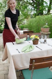Oberopfingen狮子乡村宾馆的坐在桌子上的女人,穿着桌布