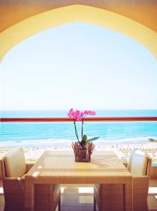 维拉摩拉Crowne Plaza Vilamoura - Algarve, an IHG Hotel的一间设有桌子并享有海滩美景的用餐室