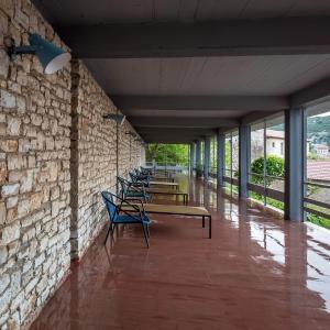 安德里塞纳塞奥克塞尼亚酒店的靠着砖墙的一排长椅,墙上有窗户