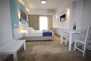 特劳洛斯Hotel Korali的卧室配有一张床和一张桌子及椅子