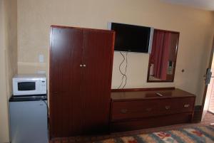 黑兹尔顿Mount Laurel Motel的一个大木柜,配有微波炉和电视机