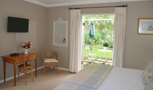 克拉伦斯Millpond House的一间卧室配有一张床、一张书桌和一个窗户。