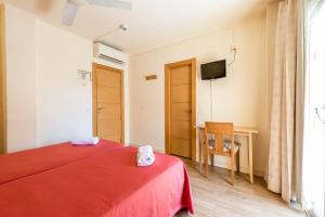 伊维萨镇普尼克欧罗巴旅馆的一间卧室配有红色的床和电视