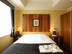 福冈福冈蒙特利拉苏瑞酒店的一间卧室配有一张床,上面有两条毛巾