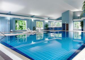 恩尼斯伍德斯托克恩尼斯酒店的大楼内一个蓝色瓷砖的大型游泳池