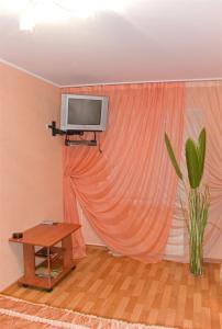 沃罗涅什MEGAPOLIS улица Кольцовская 30-А-10的配有窗帘、桌子和电视的房间