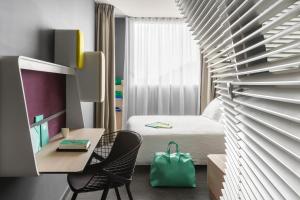 巴约讷巴约讷中心奥科酒店的客房设有一张床和一张带绿袋的书桌