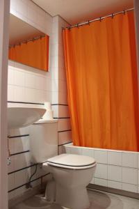 卡达克斯Hostal Cristina的浴室设有卫生间和橙色淋浴帘