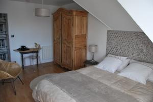 布吕兹Au Detour de Rennes的一间卧室配有一张大床和一个木制橱柜