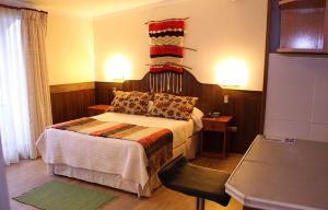 奥索尔诺鲁卡伊图埃酒店的一间卧室,卧室内配有一张床和一把椅子