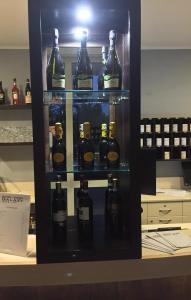 雷焦艾米利亚Hotel Motel Galaxy Reggio Emilia的装满瓶装葡萄酒的陈列箱