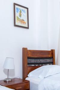 瓦拉斯Hotel & Bungalows Villa Valencia的一间卧室配有一张床和一张带台灯的桌子