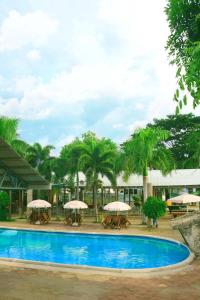 帝力帝汶酒店的一个带桌子和遮阳伞的大型游泳池