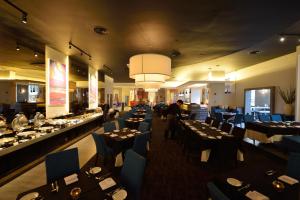古晋阿贝尔酒店的一间设有许多桌子和蓝色椅子的用餐室